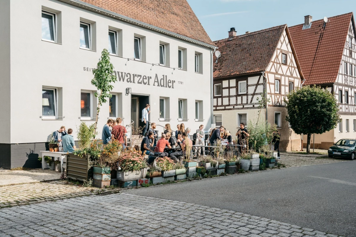 Hotel Riesengebirge: Gäste genießen sonnigen Tag vor dem historischem Gebäude des Schwarzen Adlers.