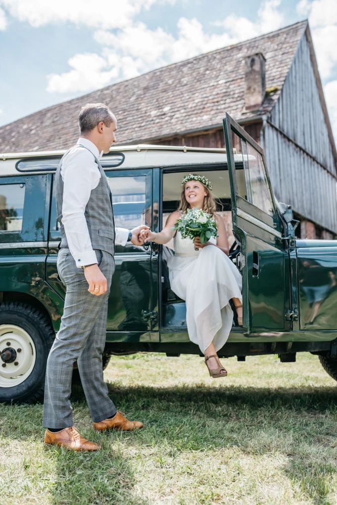 Brautpaar auf der Obstwiese des Gutshof Neun, Land Rover, Hochzeit, Sommer.