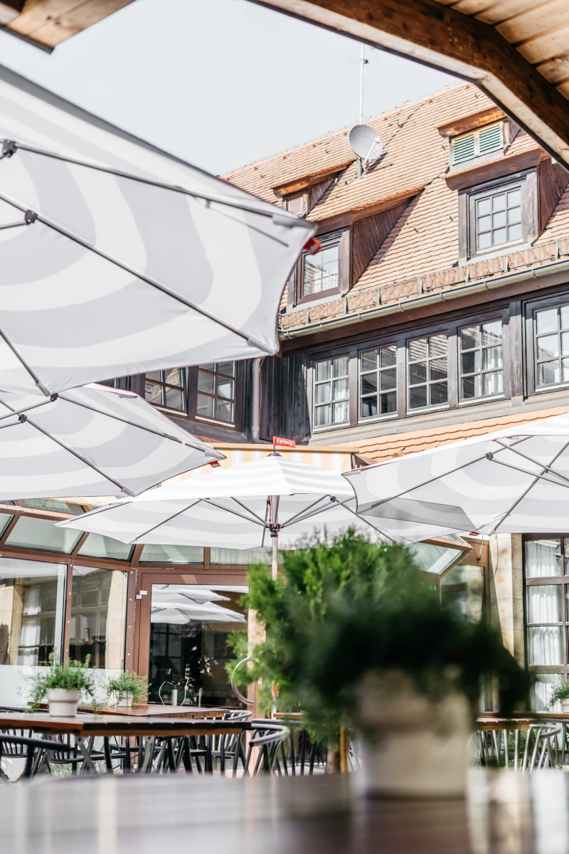 Hotel Riesengebirge Au&szlig;enbereich mit Sonnenschirmen und gem&uuml;tlicher Terrasse.